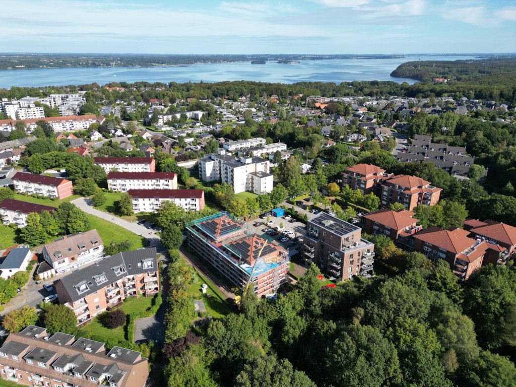 Luftansicht eines Wohngebiets mit einer PV-Anlage, die sich in der Installation befindet